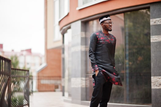Handsome afro american man wearing traditional clothes, cap and eyeglasses in modern city. photo