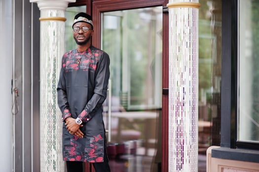 Handsome afro american man wearing traditional clothes, cap and eyeglasses in modern city. photo