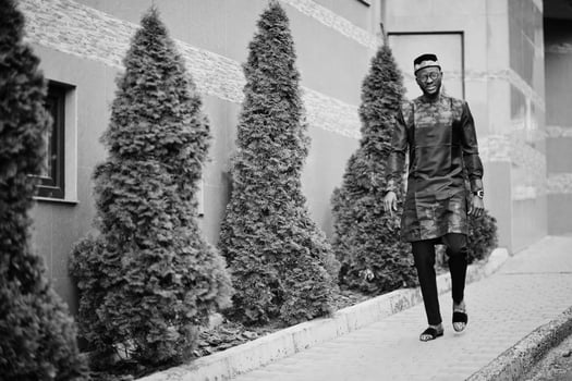 Handsome afro american man wearing traditional clothes, cap and eyeglasses in modern city. photo