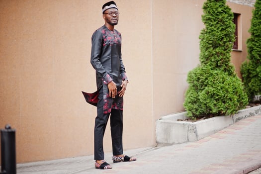 Handsome afro american man wearing traditional clothes, cap and eyeglasses in modern city. photo