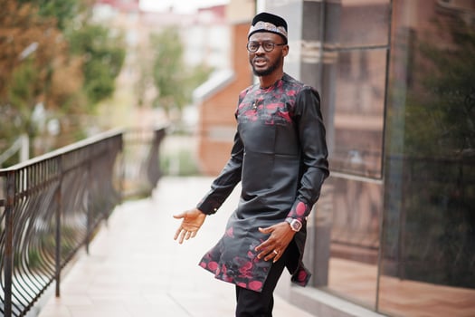 Handsome afro american man wearing traditional clothes, cap and eyeglasses in modern city. photo