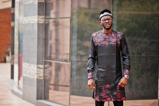 Handsome afro american man wearing traditional clothes, cap and eyeglasses in modern city. photo