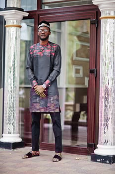 Handsome afro american man wearing traditional clothes, cap and eyeglasses in modern city. photo