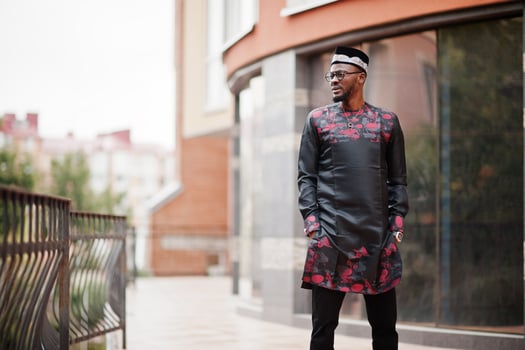 Handsome afro american man wearing traditional clothes, cap and eyeglasses in modern city. photo