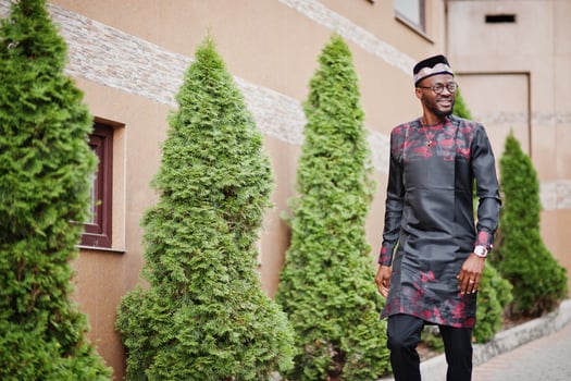 Handsome afro american man wearing traditional clothes, cap and eyeglasses in modern city. photo