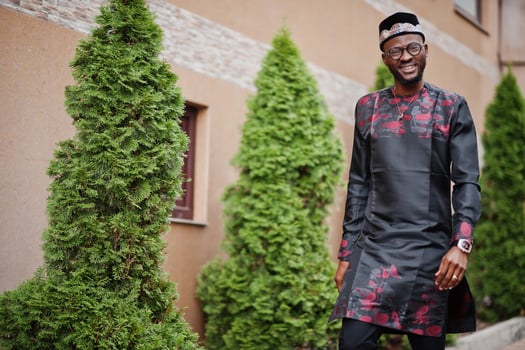 Handsome afro american man wearing traditional clothes, cap and eyeglasses in modern city. photo