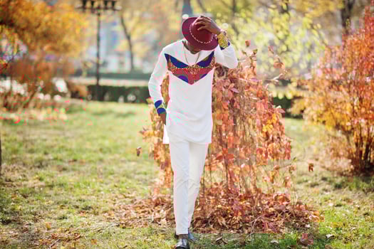 Stylish trendy afro france man in red hat and white outfit posed at autumn day. Black african model guy. photo
