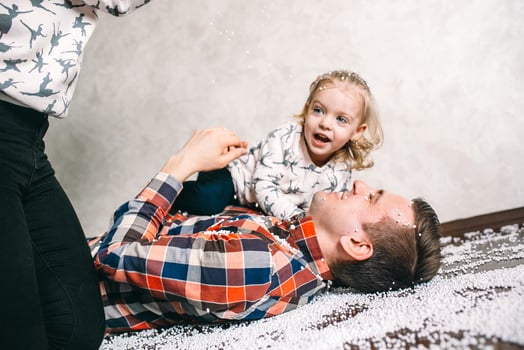 Dad plays with his daughter on the floor photo