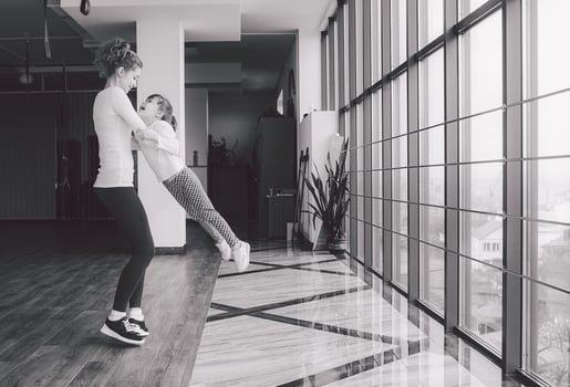 Mother twist her daughter in the gym photo