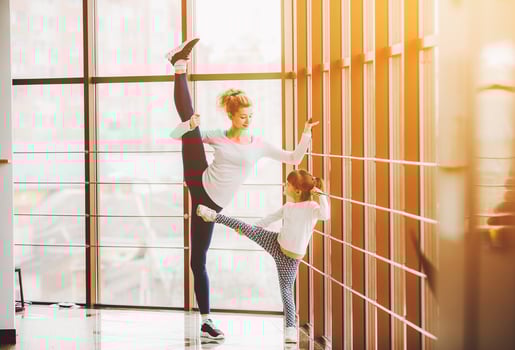 Mother learning daughter to make a high leg strech photo
