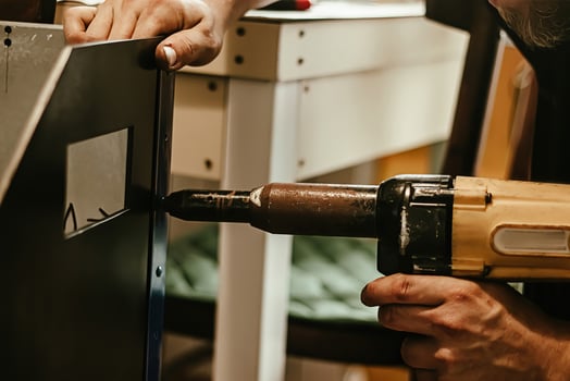Male worker uses electric riveting gun. Hand holding  riveting m photo
