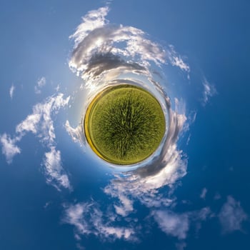 tiny planet in blue sky with sun and beautiful clouds. Transformation of spherical panorama 360 degrees. Spherical abstract aerial view. Curvature of space. photo