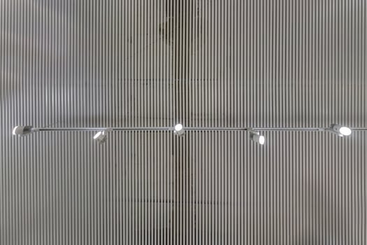 cassette suspended ceiling with square halogen spots lamps and drywall construction in empty room in apartment or house. Stretch ceiling white and complex shape. Looking up view photo