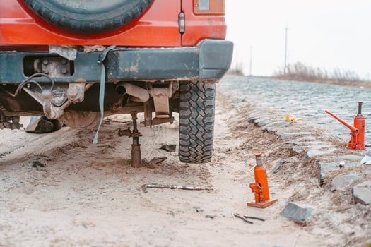 A man raises on a jack 4x4 off road truck photo