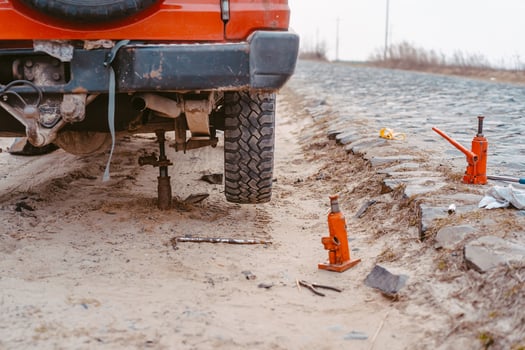 A man raises on a jack 4x4 off road truck photo