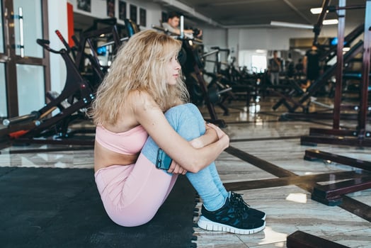 Girl sits on the floor in the gym photo