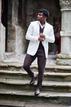 Thoughtful young handsome african american gentleman in formalwear. Black stylish model man in white jacket. photo