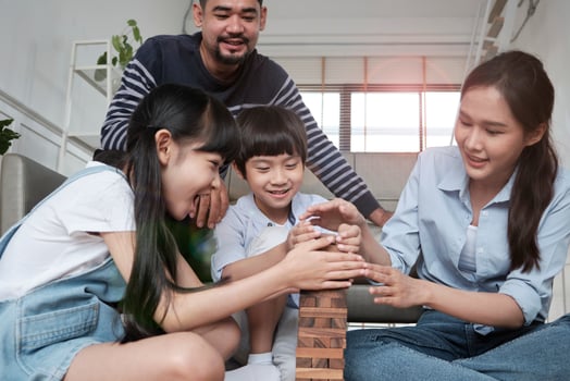 Happy Asian lovely Thai family activity, parents, dad, mum, and children have fun playing and joyful wooden toy blocks together on living room floor, leisure weekend, and domestic wellbeing lifestyle. photo