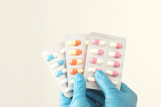 The pharmacist or doctor holds the antibiotic capsules and gives them to the patient or person. overuse of antibiotics antimicrobial resistance white background photo