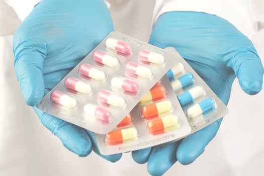 The pharmacist or doctor holds the antibiotic capsules and gives them to the patient or person. overuse of antibiotics antimicrobial resistance white background photo