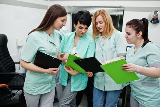 Medical theme.Observation room with a computer tomograph. The group of female doctors with clipboards meeting in the mri office at diagnostic center in hospital. photo