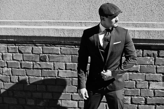 Portrait of retro 1920s english arabian business man wearing dark suit, tie and flat cap. photo