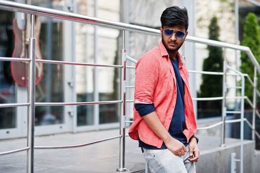 Portrait of young stylish indian man model pose in street in sunglasses. photo
