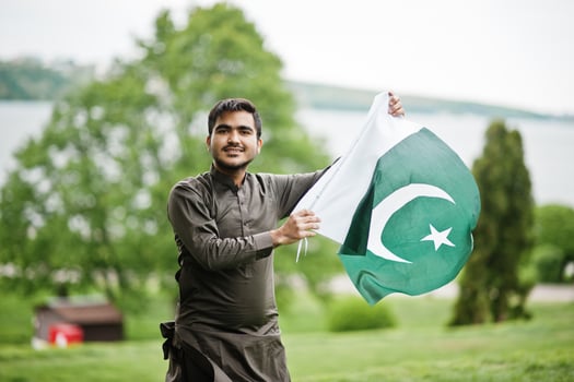 Indo pakistani man wear traditional clothes achkan or sherwani with Pakistan flag. photo