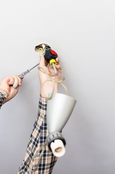 man disassembles defected ceiling lamp photo