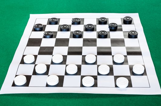 draughts on black and white checkered sheet board photo