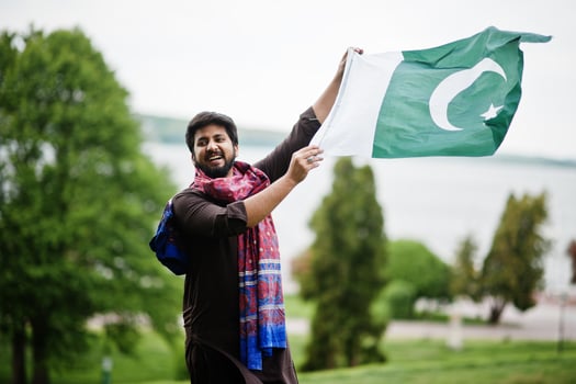 Pakistani man wear traditional clothes hold flag of Pakistan. photo