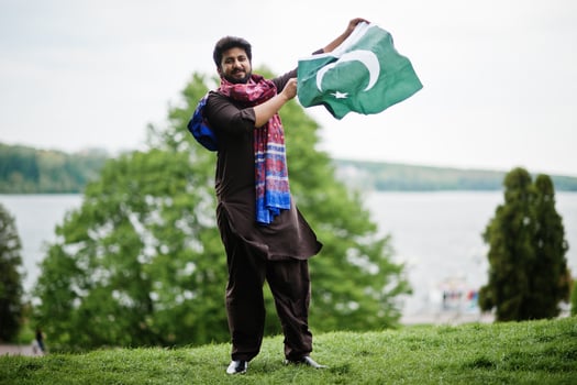 Pakistani man wear traditional clothes hold flag of Pakistan. photo
