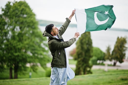 Traditional clothes indian pakistani male portrait hold Pakistan flag. photo