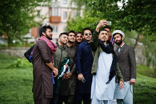 Group of pakistani man wearing traditional clothes salwar kameez or kurta making selfie on mobile phone. photo