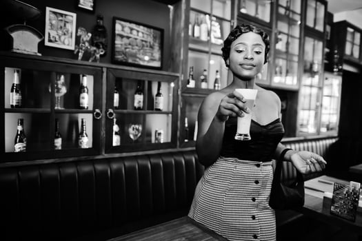 Portrait of african american woman, retro hairstyle posing at restaurant with cup of latte. photo