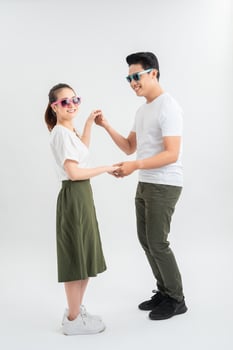smiling young couple dancing and holding hands, isolated on white photo