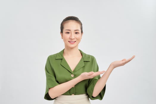 Beautiful young Asian businesswoman showing her hand to other side. Isolated over white background. photo