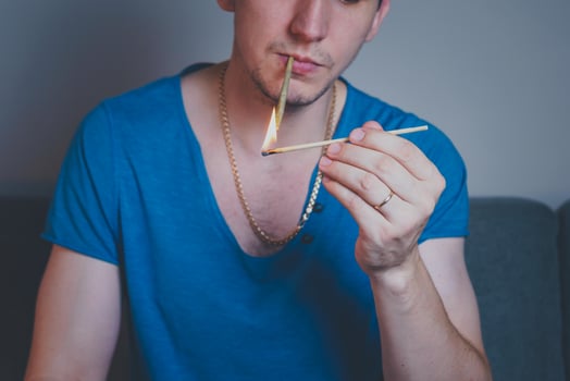 Close-up of adult man lights up with matches and smoking medical marijuana joint photo