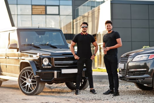 Two asian brothers man wear on all black posed near suv cars. photo