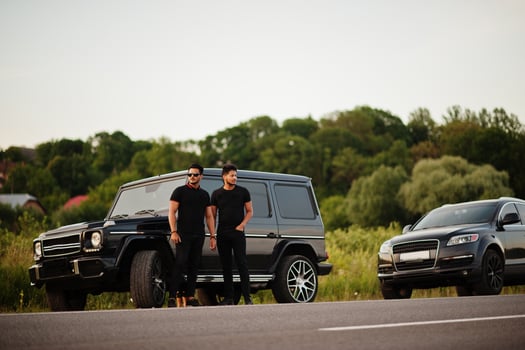 Two asian brothers man wear on all black posed near suv cars. photo