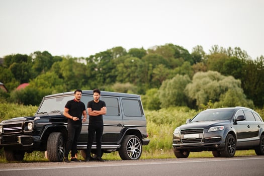 Two asian brothers man wear on all black posed near suv cars. photo