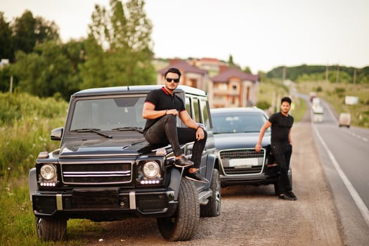 Two asian brothers man wear on all black posed near suv cars. photo