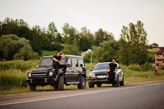 Two asian brothers man wear on all black posed near suv cars. photo