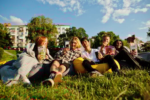 Young multi ethnic group of people watching movie at poof in open air cinema. photo