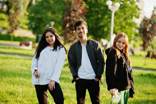 Indian man with two european girls posed outdoor. photo