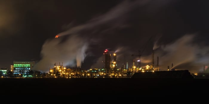 night industrial landscape environmental pollution waste of thermal power plant. Big pipes of chemical industry enterprise plant photo