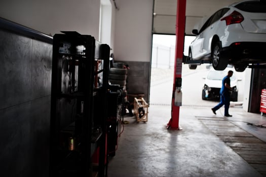 Car repair and maintenance theme. Mechanic in uniform working in auto service. photo