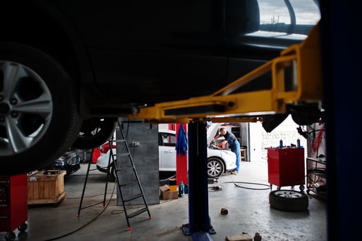 Car repair and maintenance theme. Mechanic in uniform working in auto service. photo