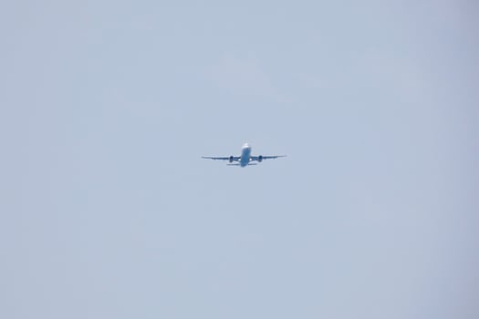commercial aircraft flying under blue skies and arriving at the airport photo