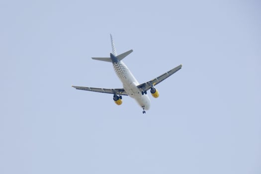 commercial aircraft flying under blue skies and arriving at the airport photo